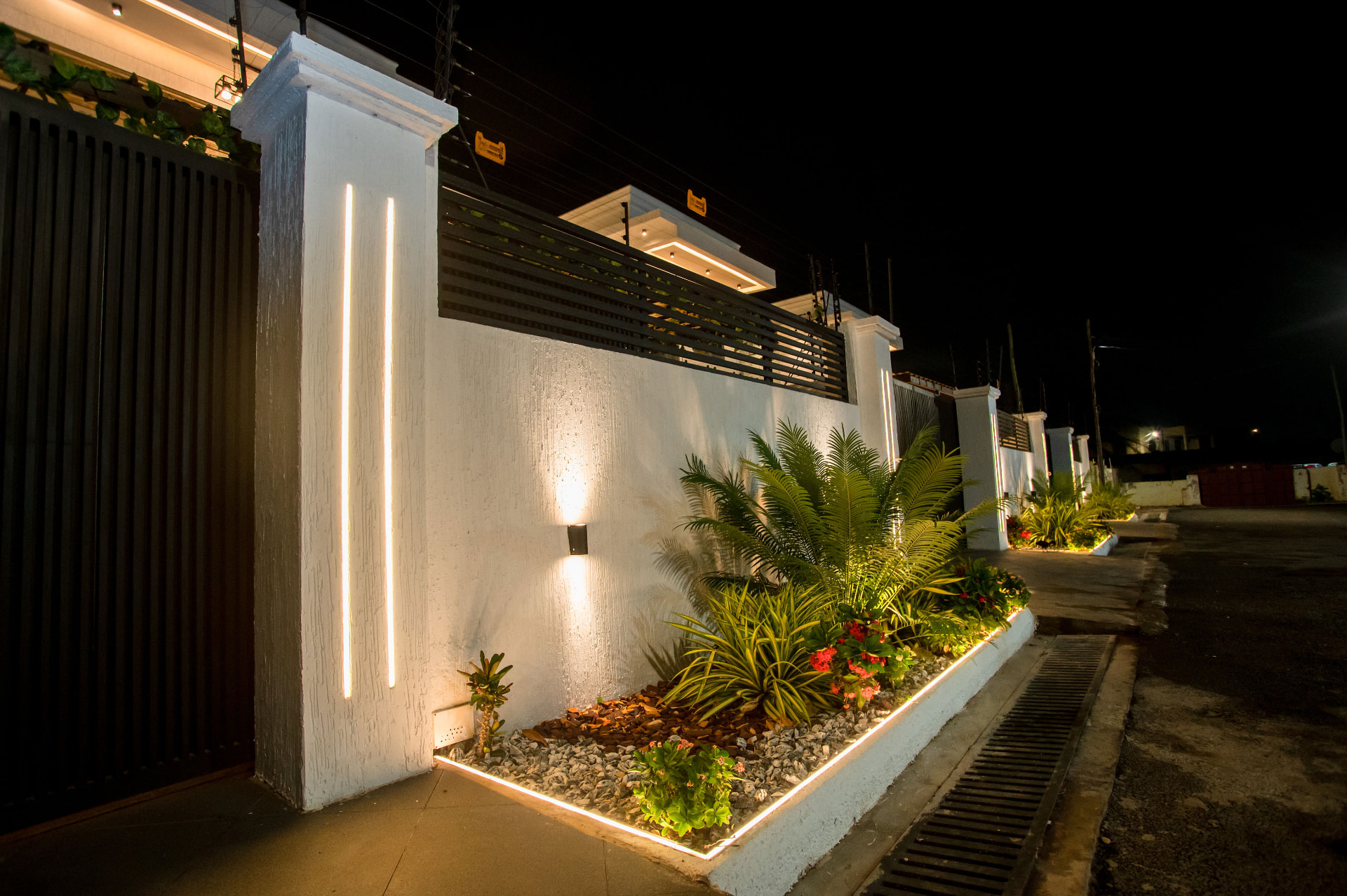 Entrance wall and planted verge at Pryse Enclave at night